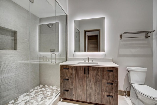 bathroom with walk in shower, vanity, and toilet