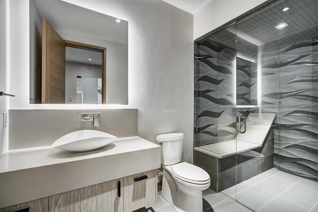 bathroom featuring toilet, a shower with door, vanity, and tile patterned flooring