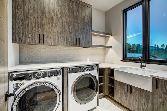 laundry area featuring cabinets, washing machine and dryer, and sink