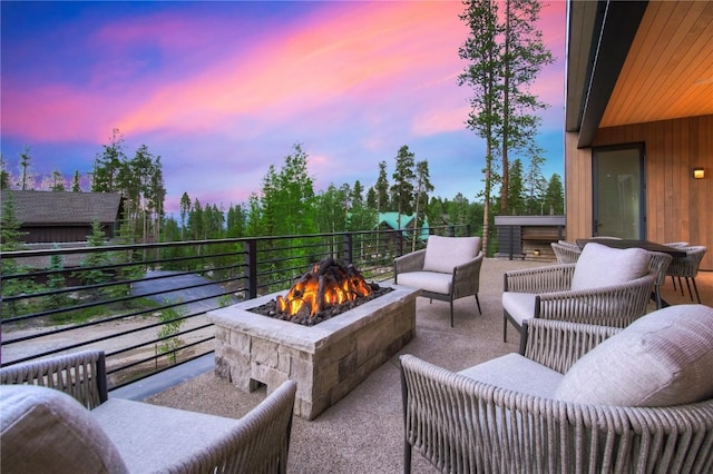 patio terrace at dusk with radiator heating unit and an outdoor fire pit