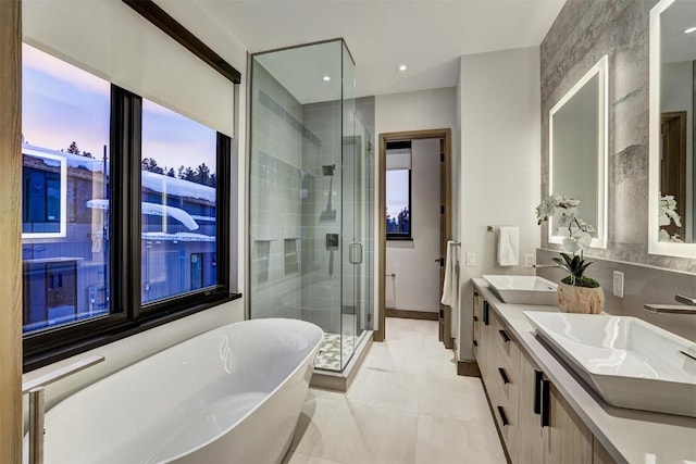 bathroom with tile patterned flooring, vanity, and shower with separate bathtub