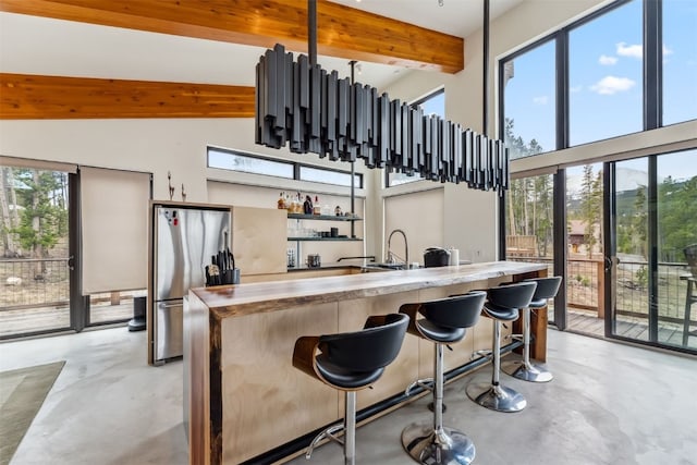 1009 American Way, Breckenridge, CO 80424 - kitchen with concrete floors, freestanding refrigerator, beam ceiling, plenty of natural light, and a high ceiling