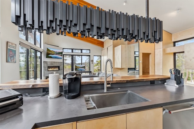 1009 American Way, Breckenridge, CO 80424 - kitchen featuring a sink, open floor plan, a towering ceiling, dark countertops, and a tile fireplace