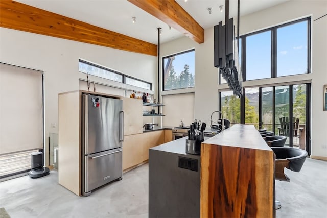 1009 American Way, Breckenridge, CO 80424 - kitchen with freestanding refrigerator, concrete flooring, a towering ceiling, beamed ceiling, and a sink