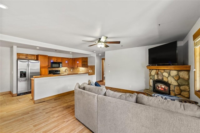 435 Ore House Plz Unit 202, Steamboat Springs, CO 80487 - living room with a ceiling fan, baseboards, light wood-style floors, a stone fireplace, and recessed lighting