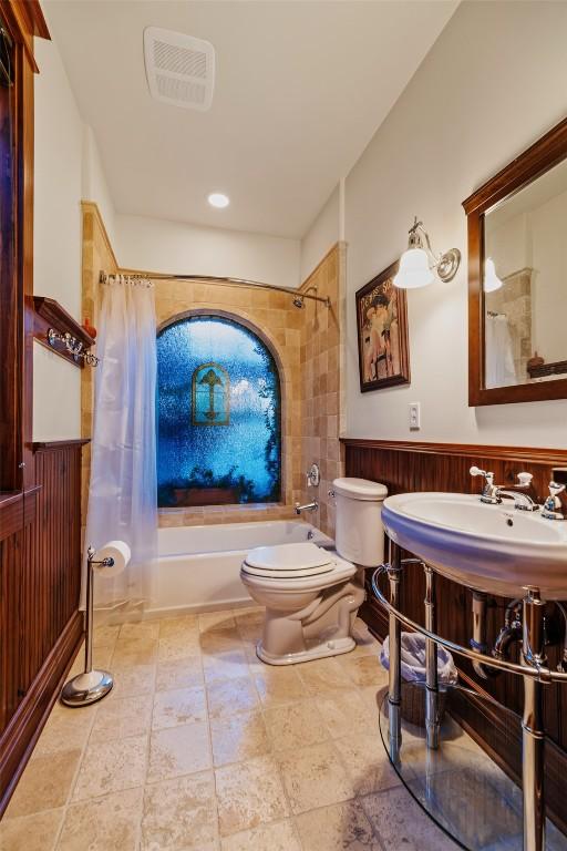 1023 Raven Way, Como, CO 80432 - full bath with toilet, wainscoting, visible vents, stone finish flooring, and shower / bathtub combination with curtain