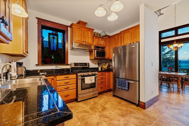 1023 Raven Way, Como, CO 80432 - kitchen with brown cabinets, under cabinet range hood, stainless steel appliances, a sink, and a chandelier