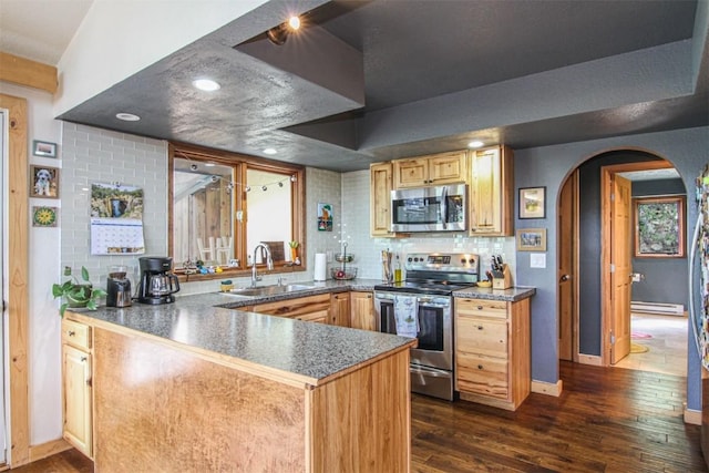 338 Deer Path Rd, Dillon, CO 80435 - kitchen featuring stainless steel appliances, baseboard heating, arched walkways, dark wood-type flooring, and a peninsula