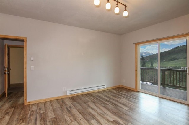 338 Deer Path Rd, Dillon, CO 80435 - empty room featuring a baseboard heating unit and wood finished floors