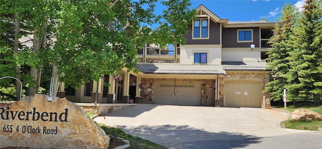 655 Four Oclock Rd Unit 209, Breckenridge, CO 80424 - view of front of house featuring stone siding, a garage, and driveway