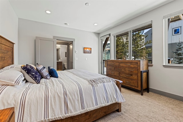 bedroom featuring recessed lighting, baseboards, light carpet, and ensuite bathroom