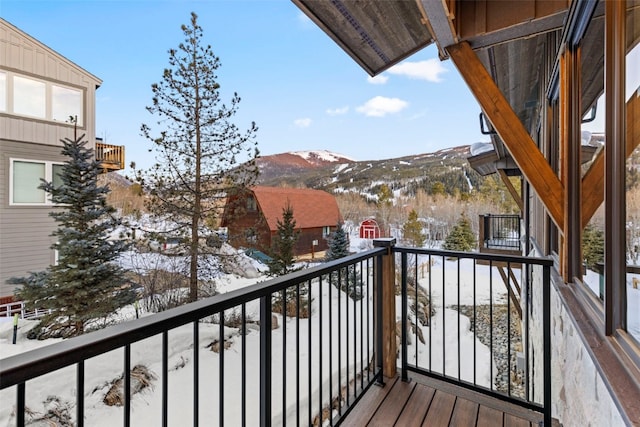 snow covered back of property featuring a mountain view