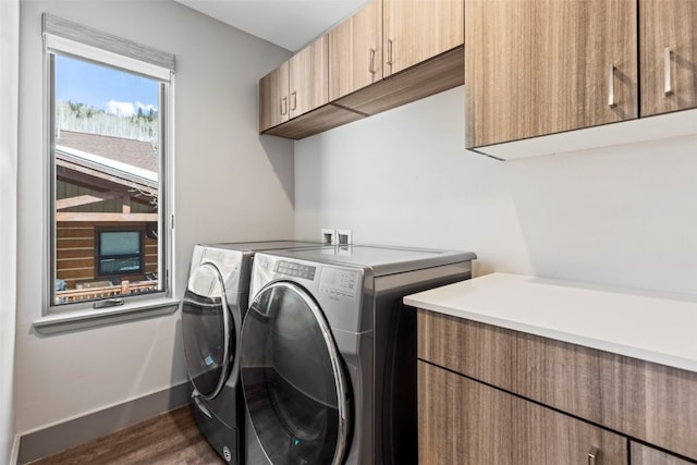 laundry area with dark wood finished floors, washing machine and dryer, baseboards, and cabinet space