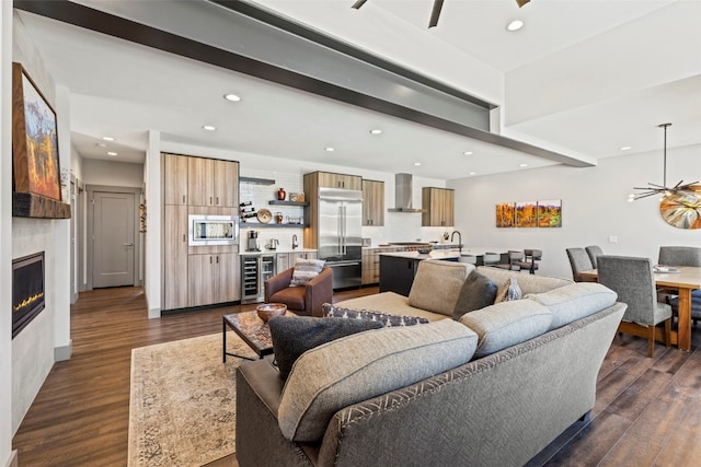 living room featuring a ceiling fan, beverage cooler, recessed lighting, and dark wood finished floors