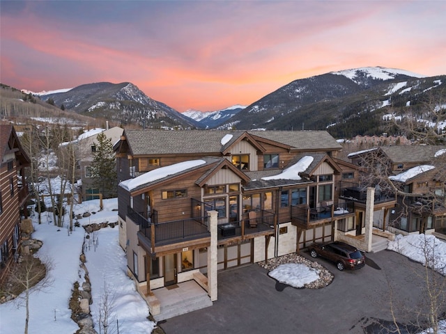 exterior space with a balcony, board and batten siding, driveway, a mountain view, and a garage