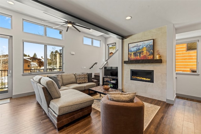 living room featuring dark wood finished floors, baseboards, recessed lighting, ceiling fan, and a fireplace