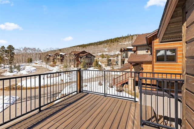 snow covered deck with a residential view
