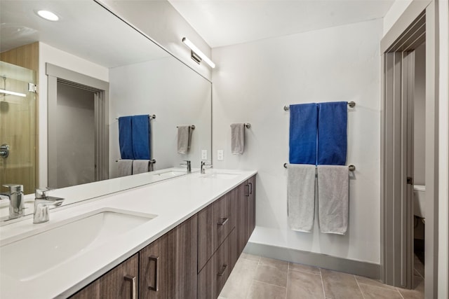 bathroom with baseboards, a stall shower, and a sink