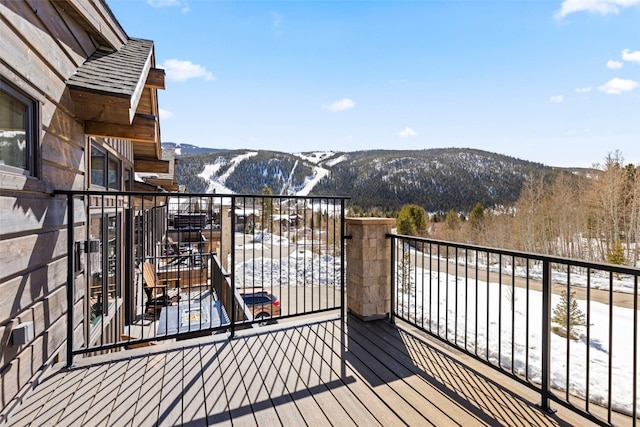 snow covered deck featuring a mountain view