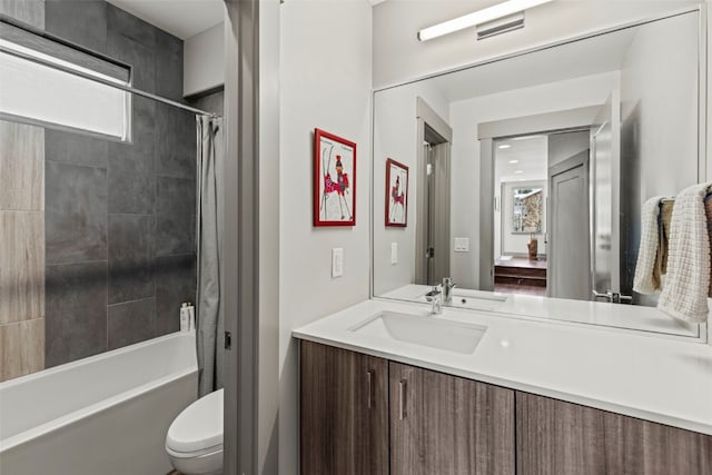 full bath featuring shower / bath combo with shower curtain, vanity, and toilet