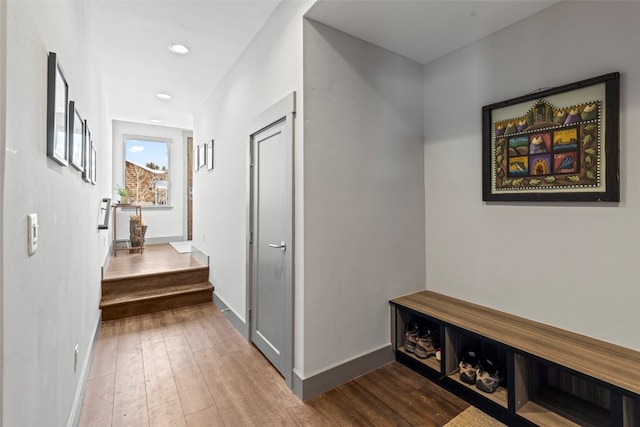 hallway with hardwood / wood-style flooring, baseboards, and recessed lighting