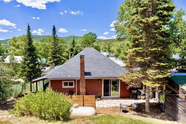 200 N Grant Ave, Oak Creek, CO 80467 - back of property with roof with shingles, a fenced backyard, a mountain view, and a patio area