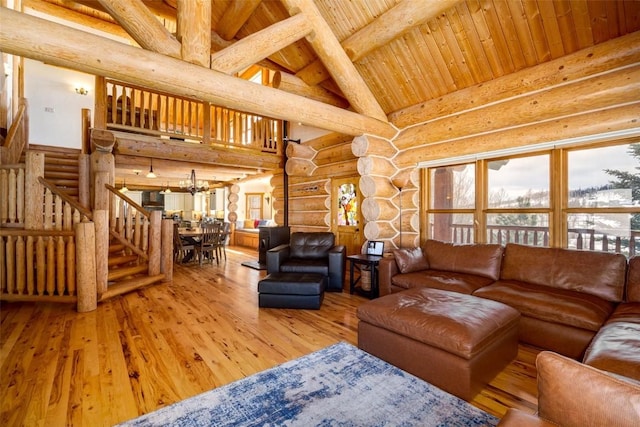 57640 County Road 129, Clark, CO 80428 - living area featuring log walls, hardwood / wood-style flooring, a wooden ceiling with exposed beams, stairway, and a chandelier