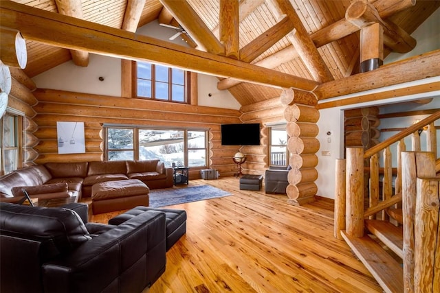 57640 County Road 129, Clark, CO 80428 - living room with high vaulted ceiling, stairway, a wood ceiling with exposed beams, light wood-type flooring, and rustic walls