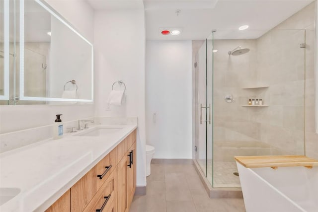 bathroom with tile patterned floors, toilet, a shower with shower door, and vanity