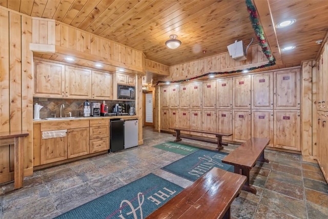 kitchen featuring black microwave, sink, light brown cabinets, and wooden ceiling