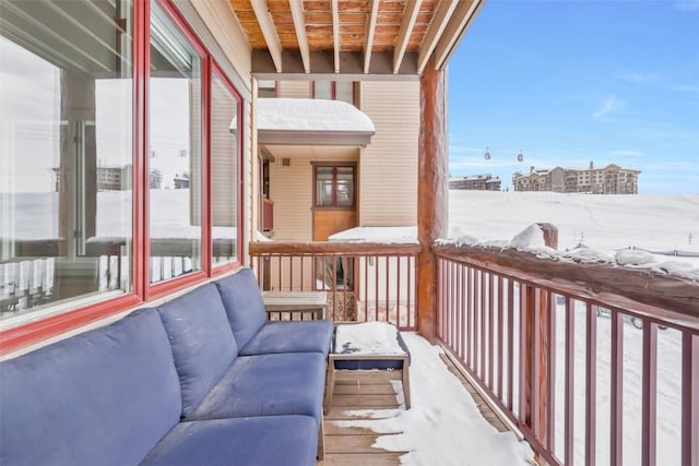 view of snow covered back of property