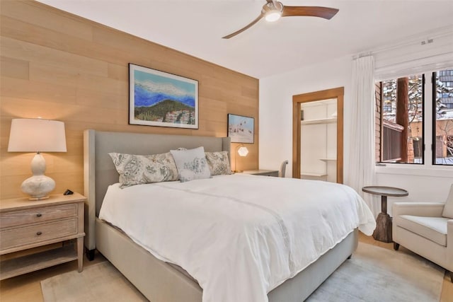 bedroom with wooden walls and ceiling fan