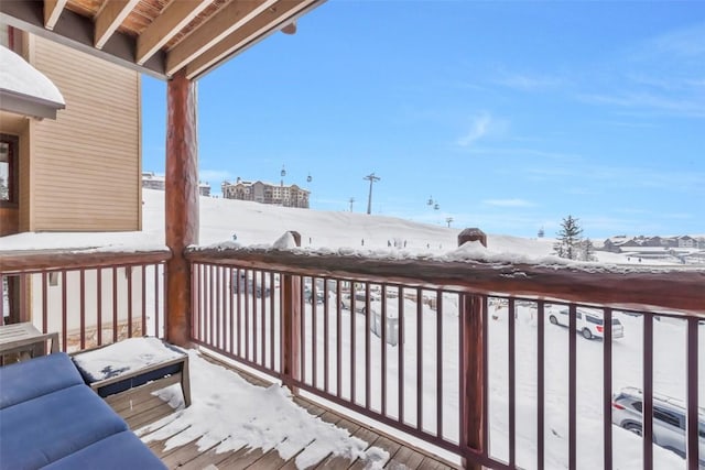 view of snow covered back of property