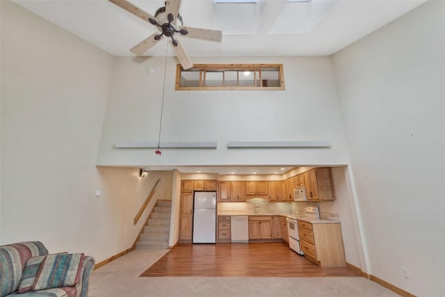 23015 Schussmark Trl Unit C, Oak Creek, CO 80467 - kitchen featuring white appliances, ceiling fan, light countertops, a towering ceiling, and a skylight