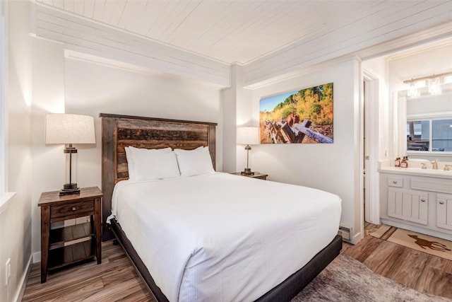 2286 Apres Ski Way Unit 105, Steamboat Springs, CO 80477 - bedroom with light wood-style floors, ensuite bathroom, and a sink