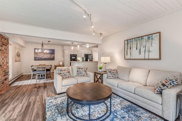 2286 Apres Ski Way Unit 105, Steamboat Springs, CO 80477 - living area with a baseboard radiator, light wood-style flooring, a chandelier, track lighting, and brick wall