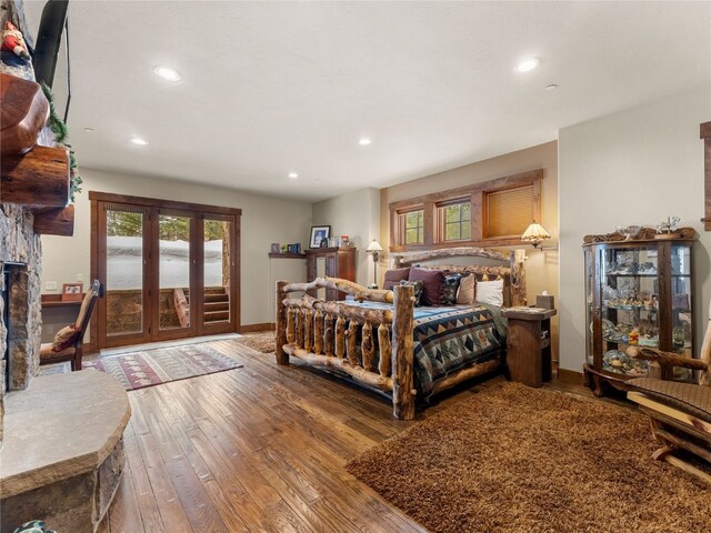 585 Independence Rd, Keystone, CO 80435 - bedroom featuring wood-type flooring, a stone fireplace, multiple windows, and recessed lighting