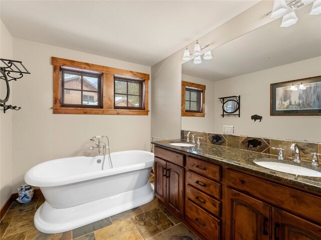 585 Independence Rd, Keystone, CO 80435 - full bath with double vanity, a sink, a freestanding bath, and stone finish flooring
