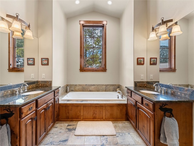 585 Independence Rd, Keystone, CO 80435 - bathroom featuring healthy amount of natural light, two vanities, a garden tub, and lofted ceiling
