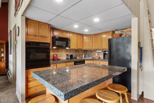 705 Snowberry Ln Unit 303, Breckenridge, CO 80424 - kitchen featuring tile countertops, black appliances, a breakfast bar, a sink, and recessed lighting