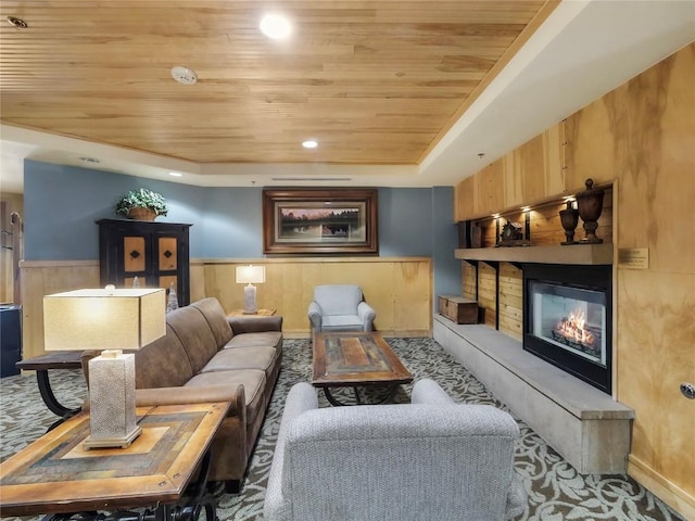 140 Ida Belle Dr Unit 8153, Keystone, CO 80435 - living area featuring wooden ceiling, carpet flooring, a raised ceiling, a glass covered fireplace, and a wainscoted wall
