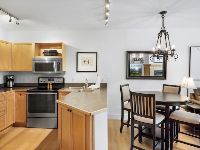 140 Ida Belle Dr Unit 8153, Keystone, CO 80435 - kitchen with appliances with stainless steel finishes, rail lighting, a peninsula, and a chandelier