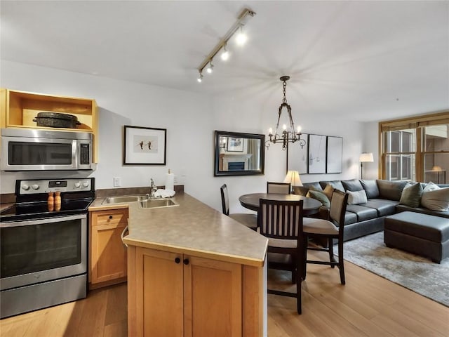 140 Ida Belle Dr Unit 8153, Keystone, CO 80435 - kitchen featuring stainless steel appliances, a peninsula, a chandelier, open floor plan, and light wood finished floors
