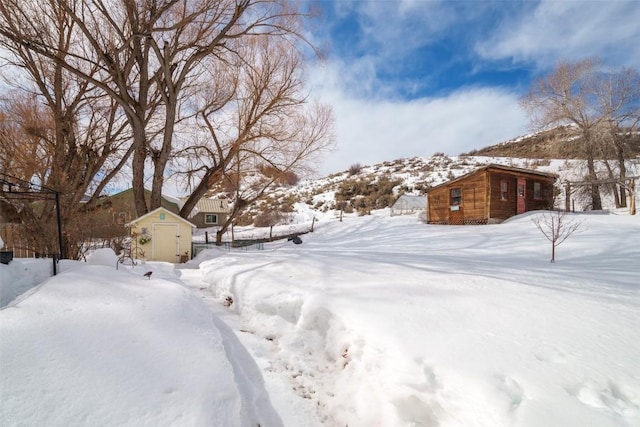 yard covered in snow with an outdoor structure and a shed