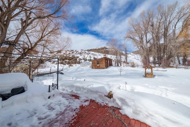 yard layered in snow featuring an outdoor structure