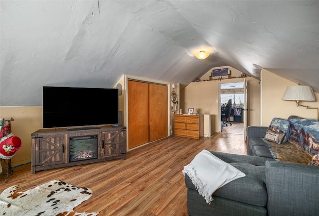 living area with vaulted ceiling and wood finished floors