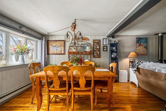 dining area featuring lofted ceiling, baseboard heating, and wood finished floors