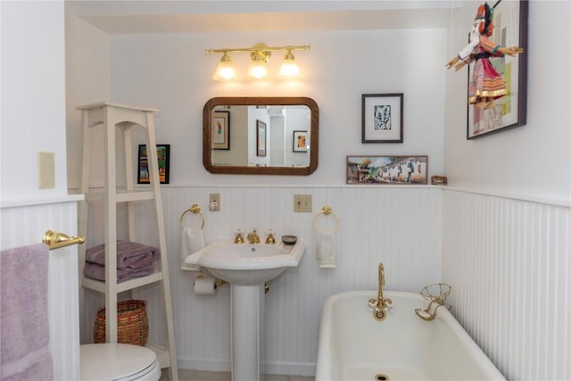 102 S High St, Breckenridge, CO 80424 - full bathroom featuring a freestanding tub, a wainscoted wall, toilet, and a sink