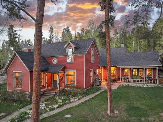 102 S High St, Breckenridge, CO 80424 - view of front of property with a chimney, roof with shingles, a yard, and a porch