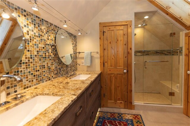102 S High St, Breckenridge, CO 80424 - bathroom featuring a stall shower, double vanity, tile patterned flooring, decorative backsplash, and vaulted ceiling